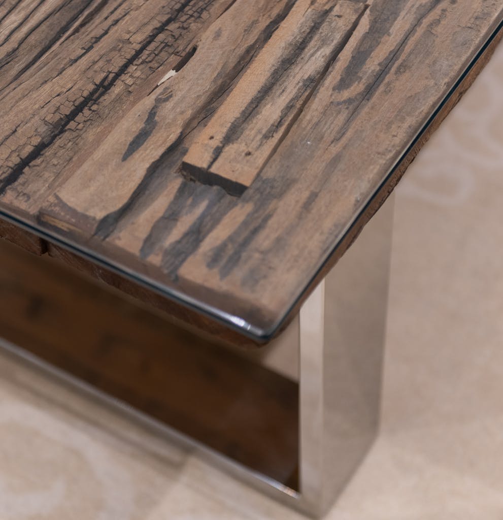 High angle of wooden brown table with metal details placed on floor in light room