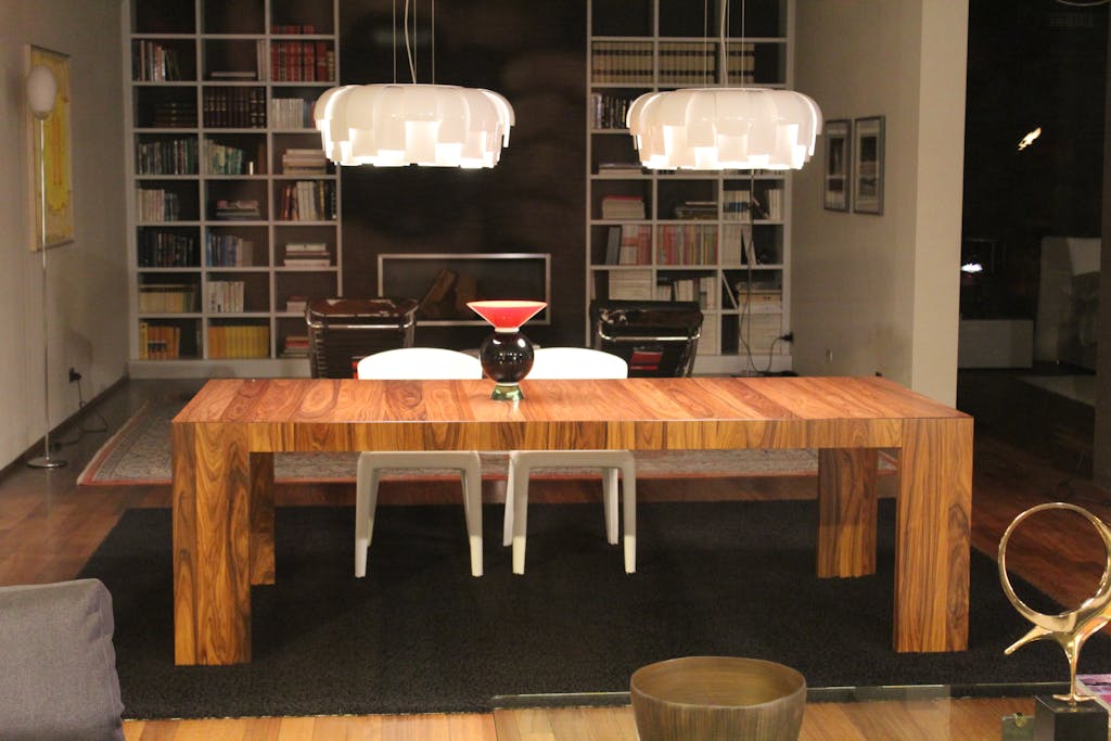 Luxurious living room featuring a modern wooden table under stylish pendant lights.